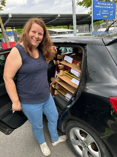 Katrin vor Ihrem Auto, das beladen ist mit vielen neuen Stühlen für die Hof-Terrasse