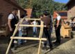 Mehrere Jugendliche bauen unter Antleitung von Zimmerern einen selbsttragenden Holzbogen aus einfachen Kanthölzern